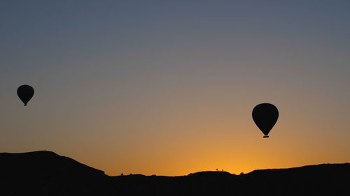 Hot air balloons flying against sky during sunset