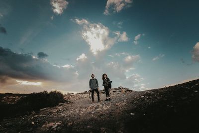 People walking on landscape against sky