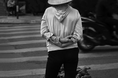 Rear view of woman walking on footpath