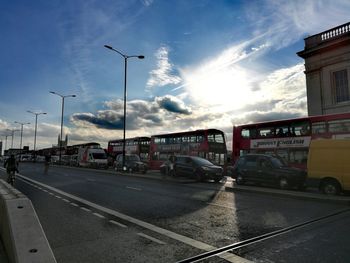 Cars on city street against sky