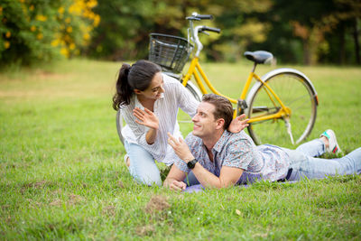 Young couple with bicycle on grass
