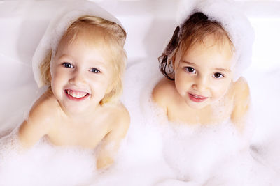 Portrait of cute girls bathing in bathtub