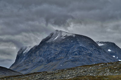 Scenic view of mountains against cloudy sky