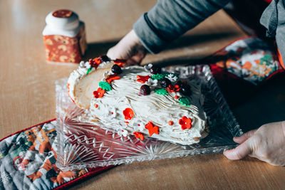 Cropped hands holding dessert on table