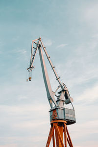 Low angle view of crane against sky