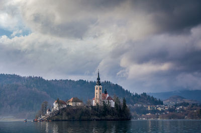 Buildings on a small island  against cloudy sky