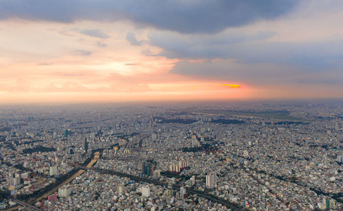 High angle view of city against cloudy sky during sunset