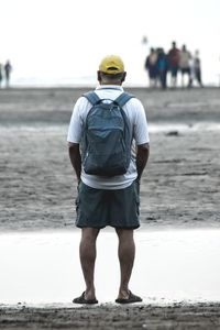 Rear view of man standing on beach