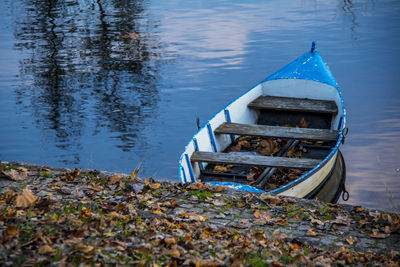 Abandoned boat moored at lakeshore