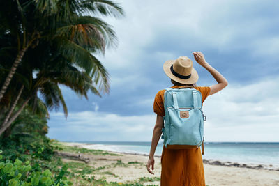 Rear view of woman standing on beach