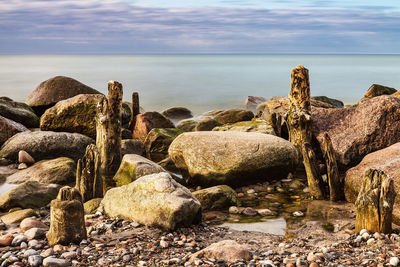 Rocks by sea against sky