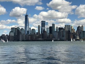 Sea by cityscape against sky