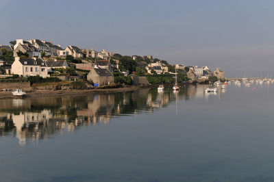 Houses by lake against sky in city