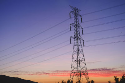 Low angle view of silhouette electricity pylon against sky during sunset