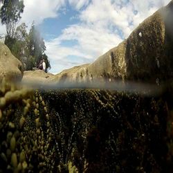 Low angle view of person on rock against sky