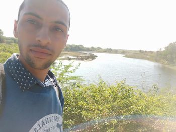 Portrait of young man against lake