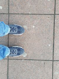 Low section of man standing on tiled floor