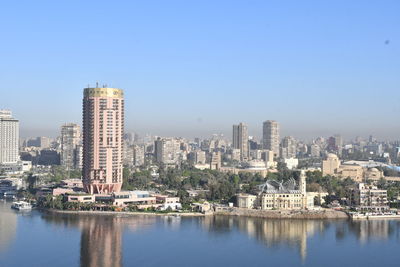 Buildings in city against clear sky