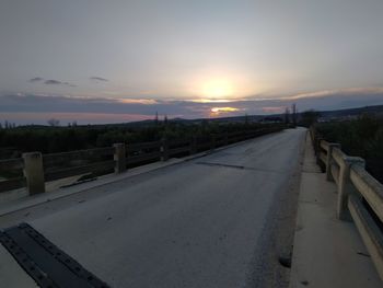 Road by street against sky during sunset in city