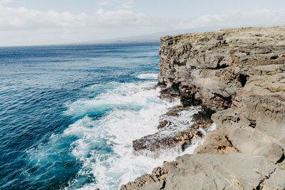 Scenic view of rocks in sea against sky