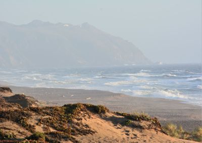 Scenic view of sea and mountains against sky