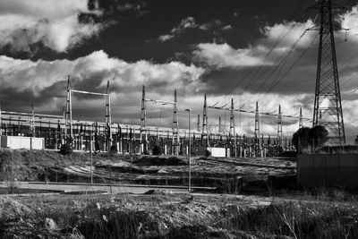 Electricity pylon on field against sky