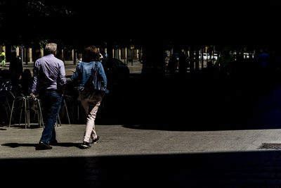Rear view of people walking in city