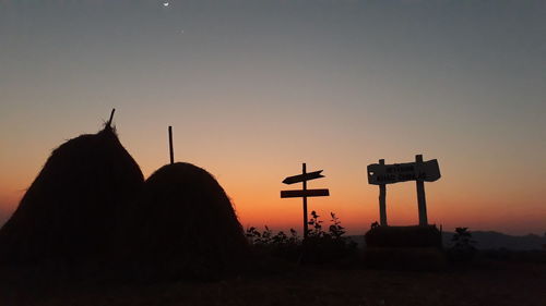 Silhouette cross against clear sky during sunset