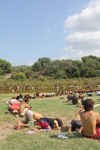 People relaxing on grassy field