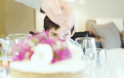 Portrait of boy seen through cake at table