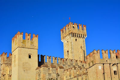 Low angle view of historic building against blue sky