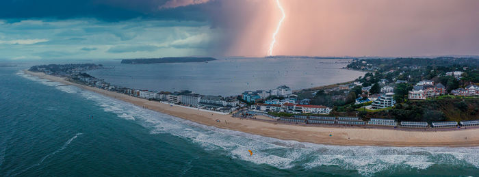 Flying over cloudy stormy beach in bournemouth, england.