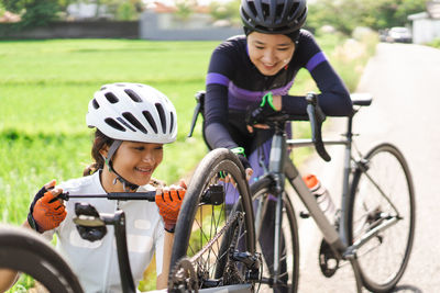 Cyclist repairing cycle on road