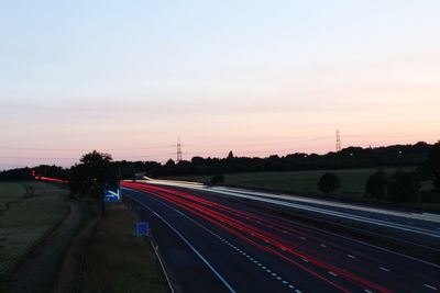 Light trails on highway at sunset