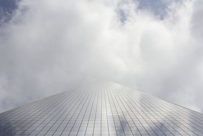 Low angle view of modern building against cloudy sky