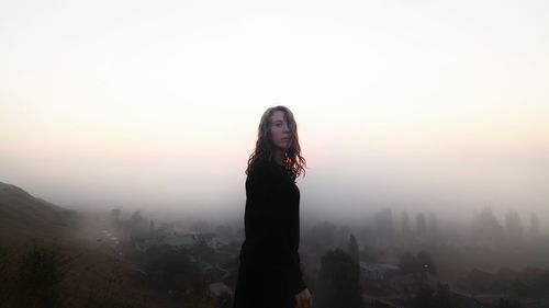 Portrait of woman standing against sky