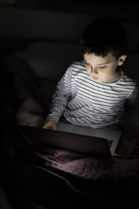 Boy watching movie on laptop at home