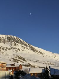 Scenic view of snowcapped mountains against clear blue sky