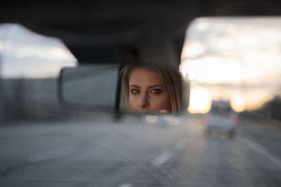 Side view of young woman in car