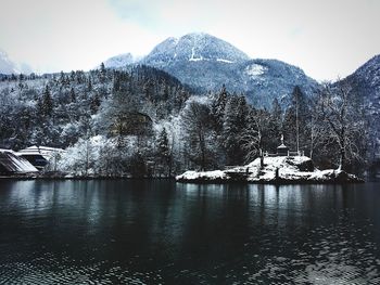 Scenic view of lake by snowcapped mountains against sky