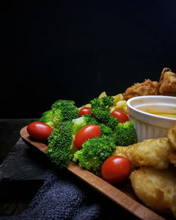 Close-up of fruits and vegetables on table against black background