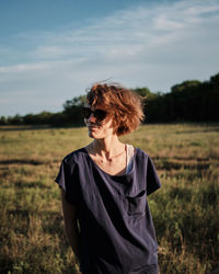 Woman standing on field against sky