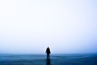 Rear view of man standing on beach