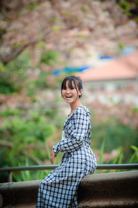 Portrait of a smiling young woman sitting outdoors