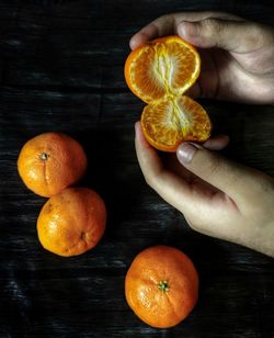 Close-up of hand holding orange on table