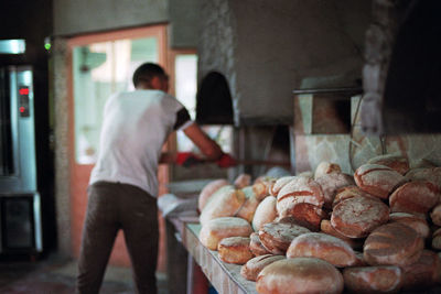 Rear view of man preparing food at store
