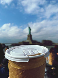 Close-up of coffee cup on table against sky