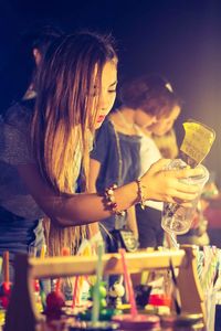 Young woman holding drink in bar