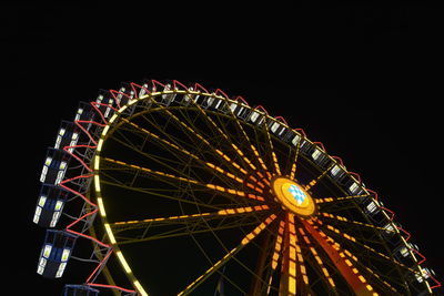 Low angle view of illuminated ferris wheel against sky at night