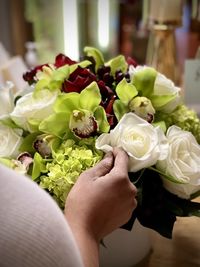 Close-up of hand holding rose bouquet